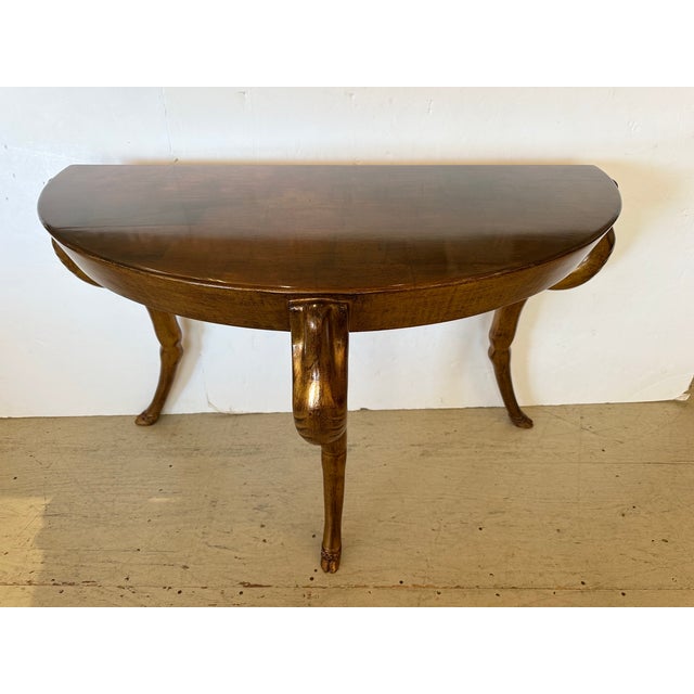 Super elegant console table having faux gold leaf finish and glossy French polish, with 3 very stylized angular legs...