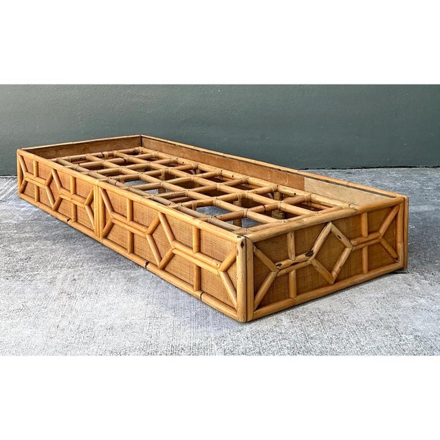 This vintage chaise platform is a long, low rectangular frame built entirely from honey-toned rattan, with a strong...