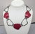 1990 hematite finish and red enamel necklace with hook clasp. Marked "MONET©." Measures: 7 3/4 inches long by 6 5/8 inches...