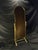 A distinctive freestanding cheval mirror frame featuring an elongated arched form, gold-tone metal construction, and...