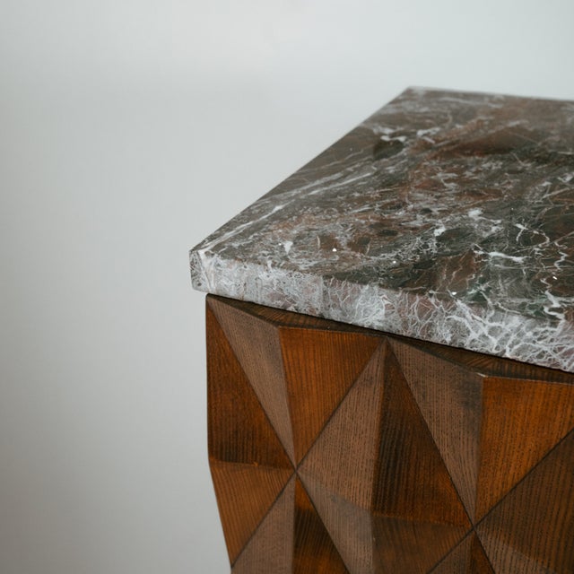 Crafted from ash wood, this cabinet features a front adorned with geometric, diamond-shaped reliefs, lending depth and...