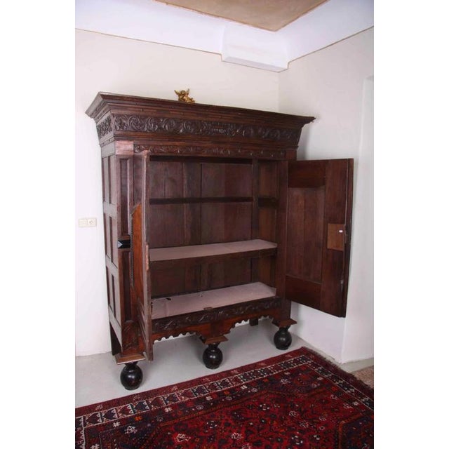 Early Baroque Dutch solid oak cabinet decorated with carvings of Putti carrying a bowl of fruit, a rich floral carved...