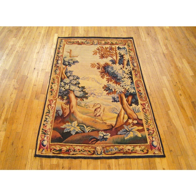 A French Aubusson verdure landscape tapestry from the 18th century, with a crane at the center of the idyllic landscape...