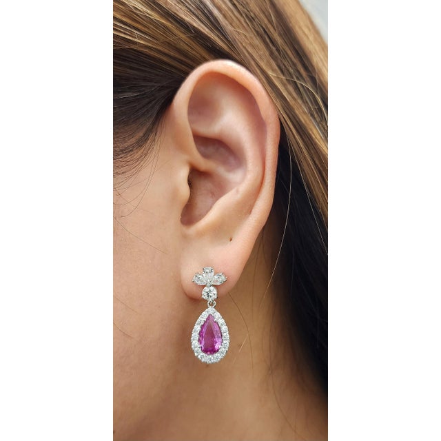 Experience the epitome of luxury with these exquisite drop earrings. Showcasing natural, stunning pink sapphires weighing...
