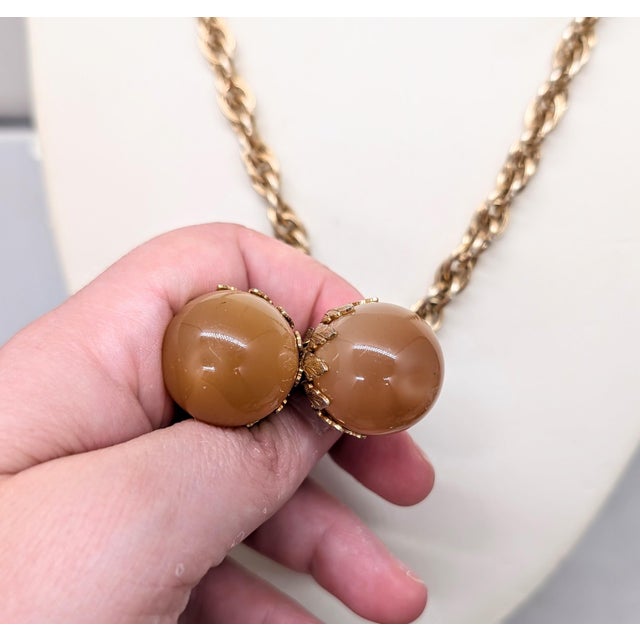 1960s goldtone two spherical resin "peach" tan moonglow drops with goldtone leaves around the tops necklace with spring...
