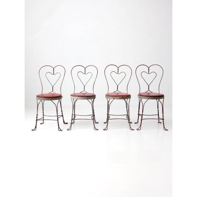 Vintage 1960s Simpson Bosworth wrought iron dinette set featuring a round dining table and four matching heart-back...
