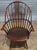 Chair has a bent back with spindles with rail back support, shaped arms with carved paddles, carved shield seat resting on...