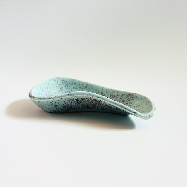 A mid century ceramic tray. Nice kidney shape. Glaze is blue with speckled purple. Measures 7.5"W x 4.25"D x 1.5"H