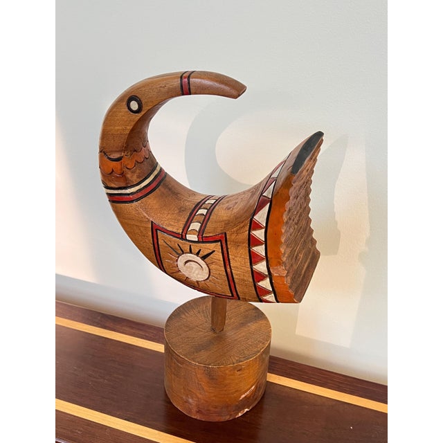 Hand-carved wood sculpture of a stylized bird, mounted on its original turned wood base. This is a distinctive one-of-a-...