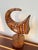 Hand-carved wood sculpture of a stylized bird, mounted on its original turned wood base. This is a distinctive one-of-a-...
