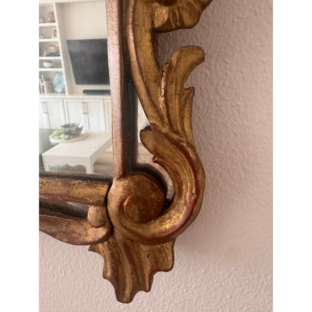 A beautifully aged Rococo-style giltwood mirror, carved in high relief with flowing acanthus leaves, C-scrolls, and a...