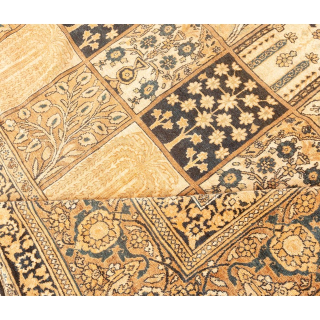 A late 19th century Persian Kerman carpet, the overall tile design in a palette of beiges and black with each compartment...