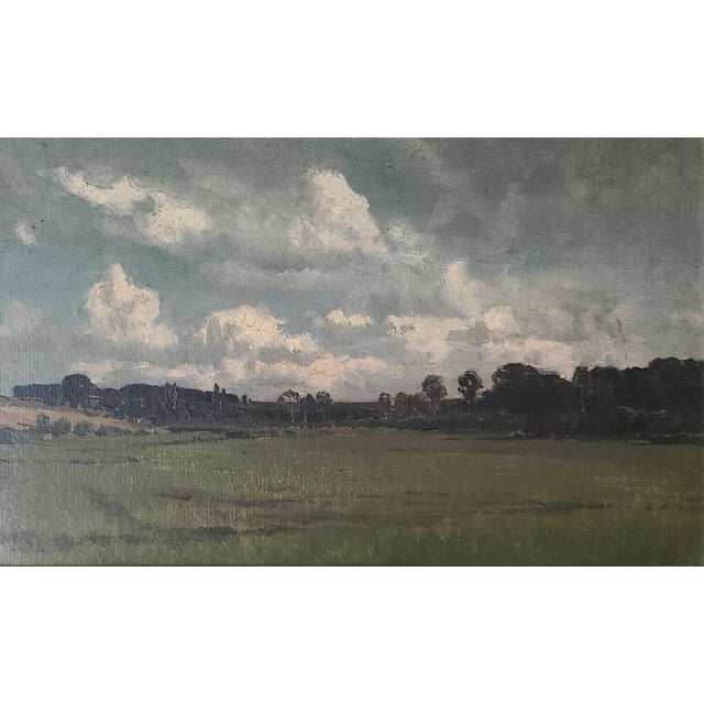 Small antique oil painting of an expansive landscape under clouds. Original and one of a kind. The medium is oil on board....