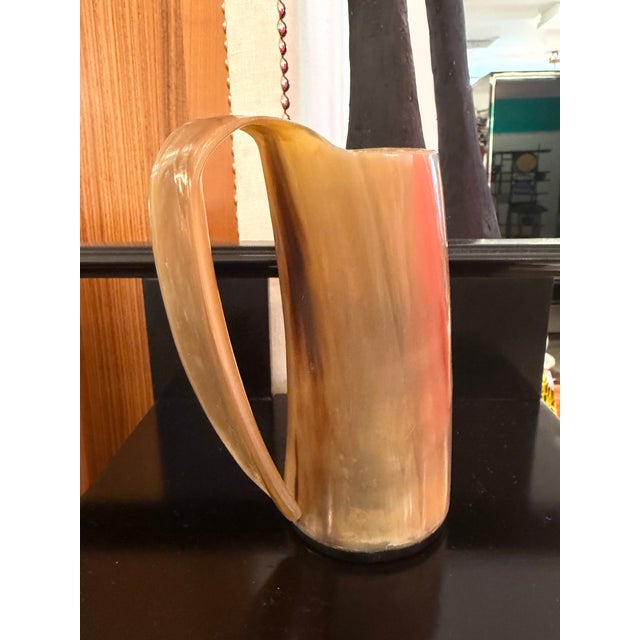 Wonderfully hand polished natural horn cup. The handle is a continuation of the cup and has a decorative flare.
