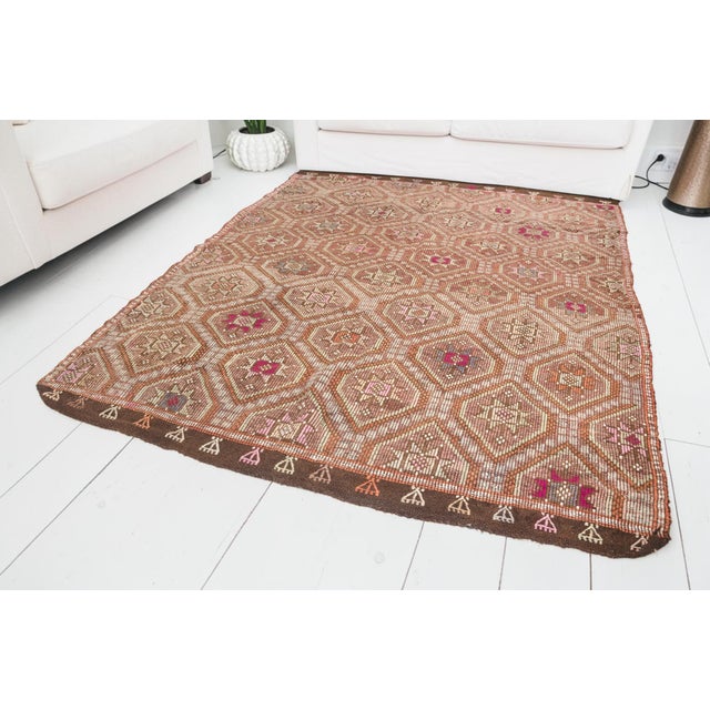 This is a vintage Turkish Oushak rug from the Mid 20th Century. The piece was hand-knotted.