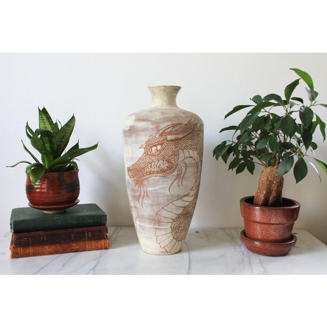 Gorgeous vintage studio pottery vase featuring an incised dragon motif. Pale, cream-tinted body and the way the reddish-...