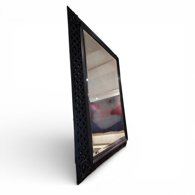 The frame features finely carved detailing with a rich black finish that highlights the depth and intricacy of the...