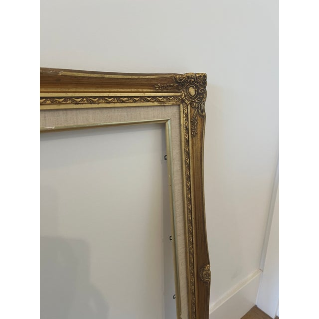 Beautiful vintage wood picture frame with an aged gilt finish, carved floral corner details and a wide linen liner. Sized...