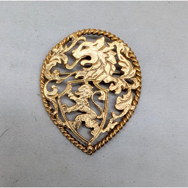 1970s tear drop shaped goldtone cut out rearing lion coat of arms brooch with security clasp. Marked "NAPIER©" on the...