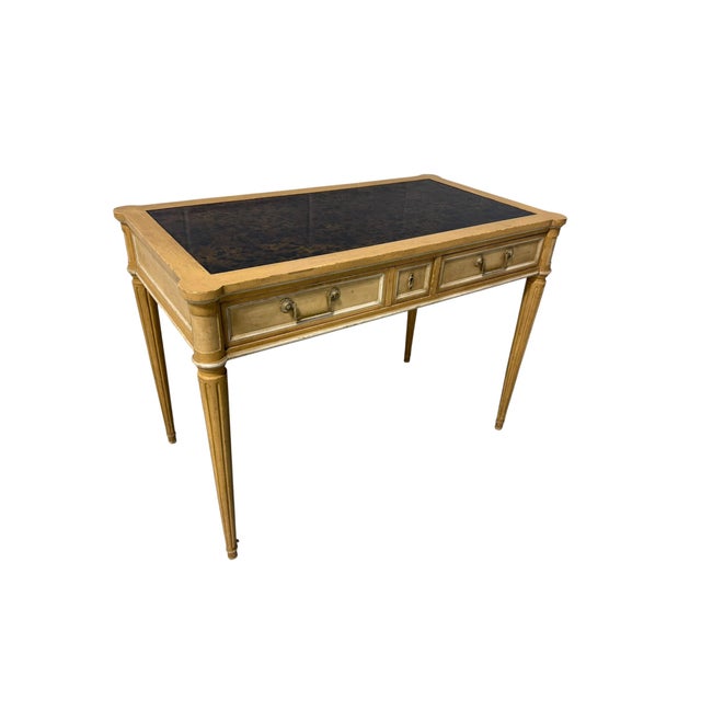 This vintage Baker Furniture writing desk features an original mottled leather writing surface, three drawers with a...