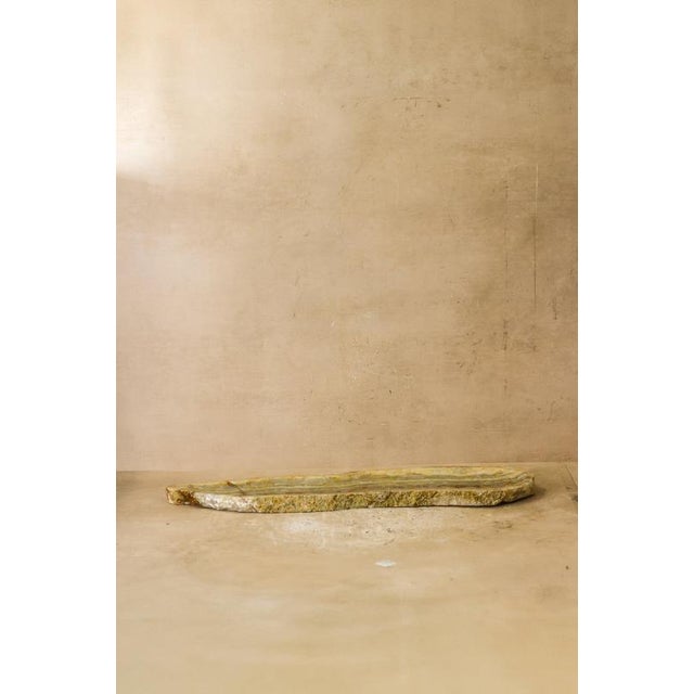 A long raw-edge tray hand-carved from a single piece of natural onyx. The polished channel runs the length of the stone,...