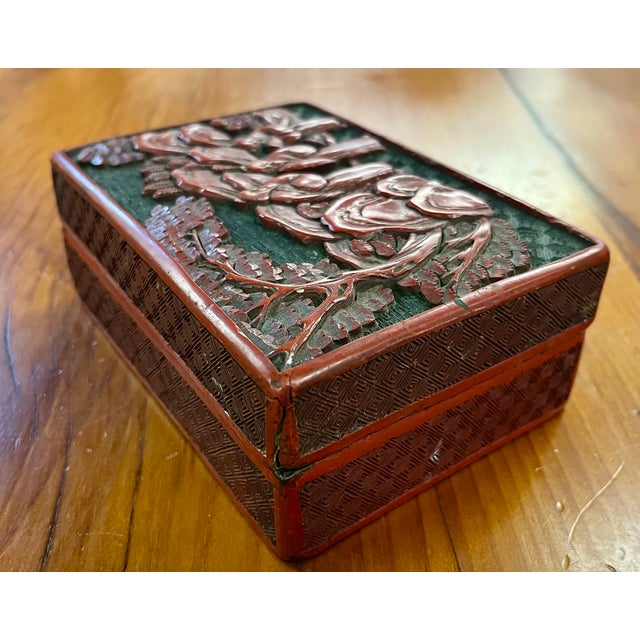 Antique 19th century Chinese carved cinnabar lacquer box. Decorated with court figures in a traditional landscape. The...