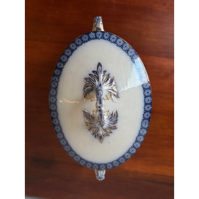 Elegant antique European porcelain covered tureen, decorated in a rich blue flow pattern, featuring sculptural winged...