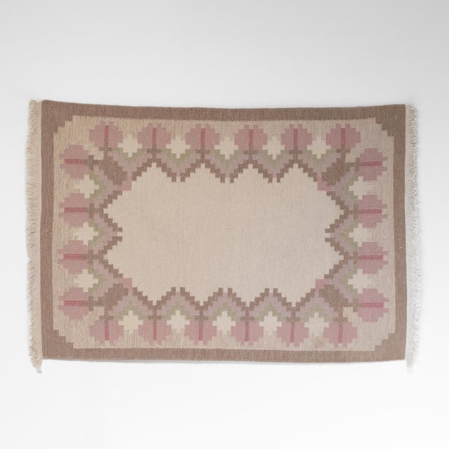 Mid-Century Swedish kilim in pale tones of creams, browns and pink. Sweden circa 1960. All our rugs undergo a professional...