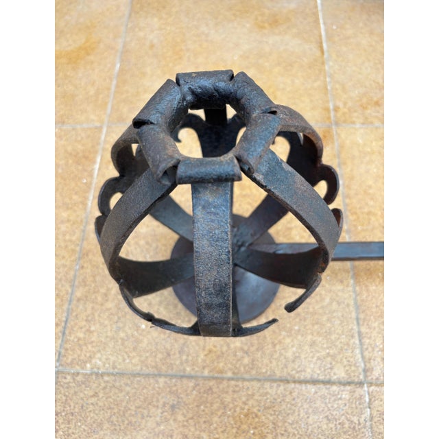 Elegant pair of Spanish forged-iron andirons dating from circa 1880–1920. Each piece features a sculptural basket-form...