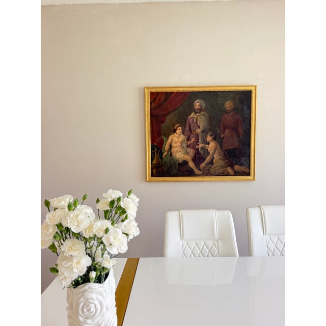 This substantial antique Orientalist oil painting on canvas presents an elaborate courtly interior centered upon a richly...