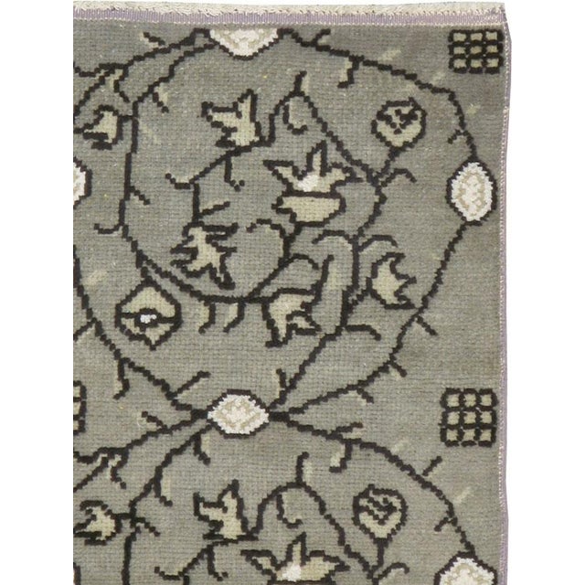 This mid-20th-century Turkish Anatolian throw rug presents a disciplined allover composition of paired floral medallions...