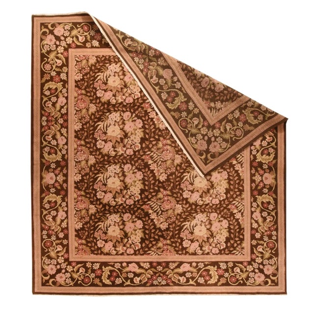 In a European needlework carpet or Bessarabian flatweave, this moderately well-woven modern square rug shows a dark red...