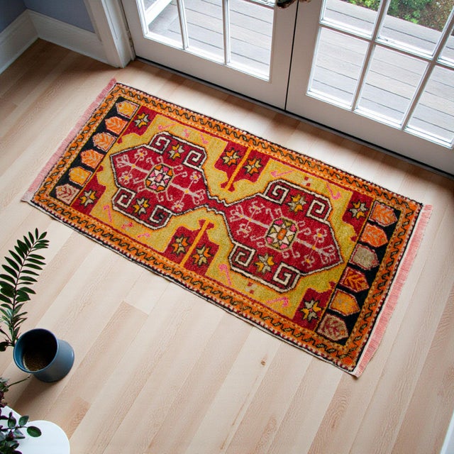 This vintage Chal rug features a striking geometric composition with bold medallions and a vibrant, warm color palette....