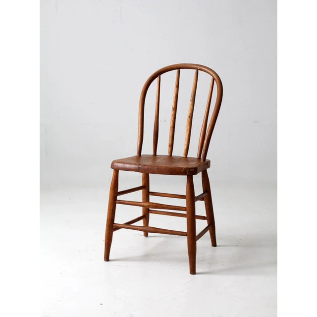 This is an antique bow back Winsdor chair. The classic farmhouse dining chair has a round spindle back. Beautiful patina...