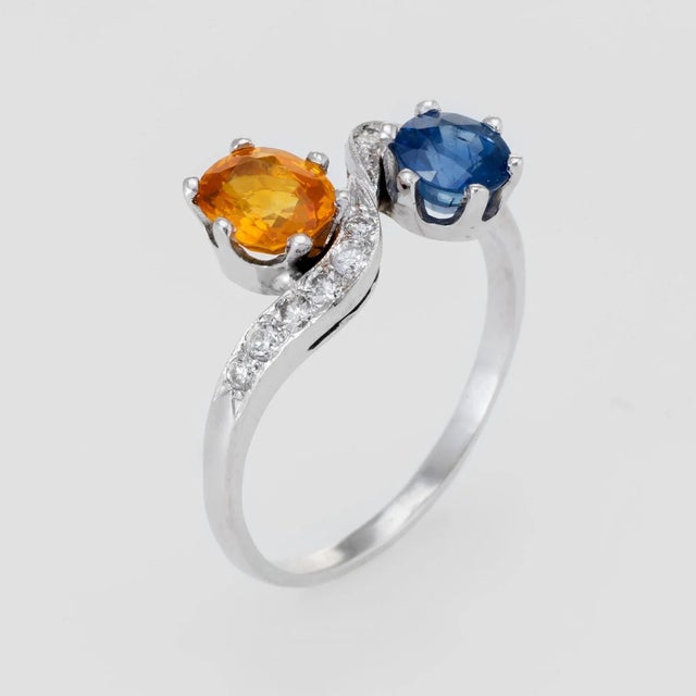 Elegant vintage bypass ring (circa 1950s to 1960s), crafted in 18 karat white gold. One round mixed cut Natural Sapphire,...