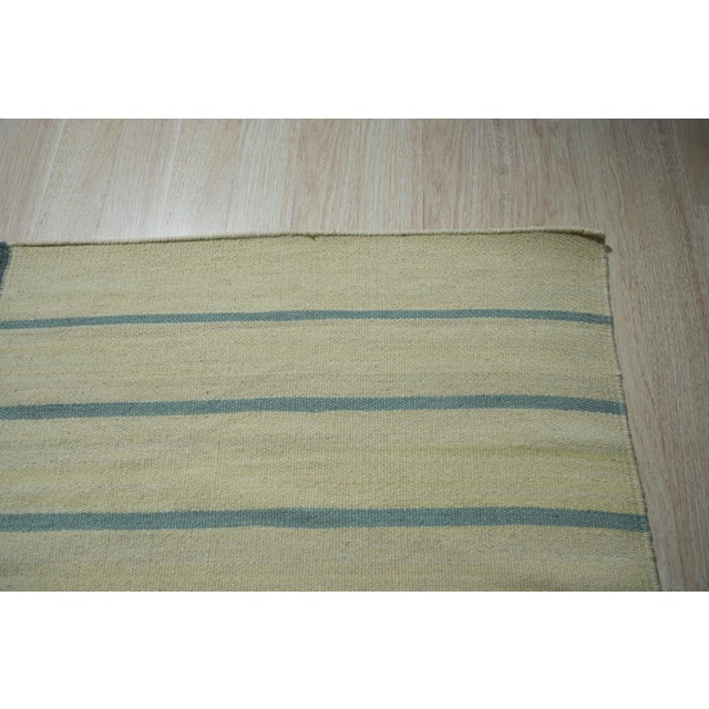 A handwoven wool flatweave, made in India and measuring 9' x 12'. No pile means the geometry is woven through the...