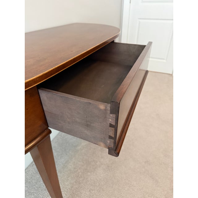 Classic and transitional style demi lune table from Holland MacRae, Atlanta. Antique reproduction. Polished walnut finish...