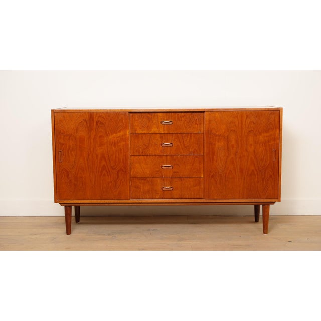 This vintage sideboard immediately stands out for its beautiful design; the drawers and doors feature minimalist wooden...