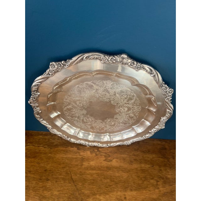 A refined American silverplate tray by 1847 Rogers Bros in the “Heritage” pattern, distinguished by its sculptural floral...