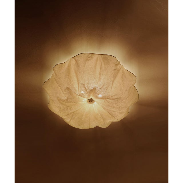 Out of production for decades, this ceiling lamp captures attention with its lightness. Made of a warm linen/cotton...