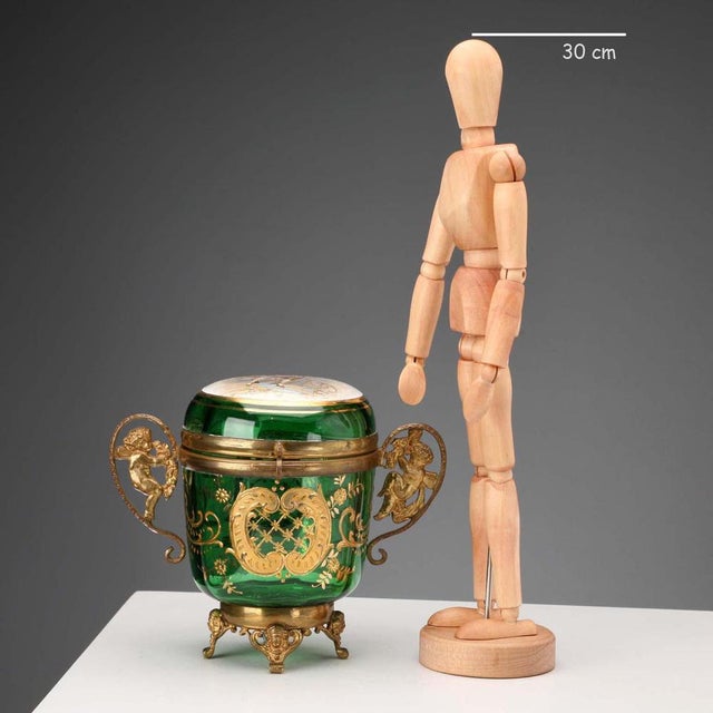 Emerald green glass jewelry box with an elegant gold scroll decoration. Lid with a polychrome decal depicting a romantic...