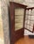 A well-proportioned, two-piece corner cabinet or cupboard with a carved dentil molded crown top, canted corners, true...