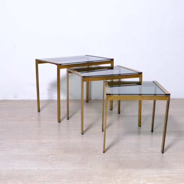 Beautiful set of 3 nesting coffee tables, in brass and smoked glass. Dimensions: 1* 60x40x50 cm h 2* 50x40x45 cm h 3*...
