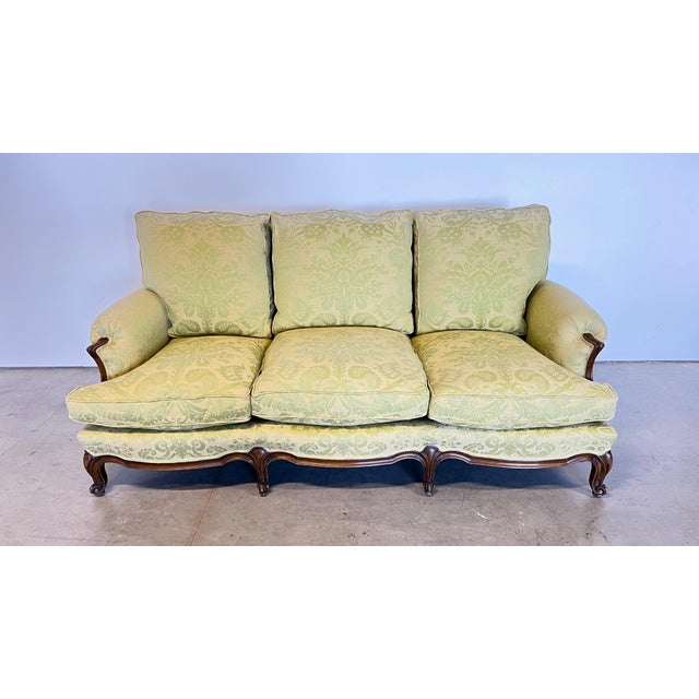 This luxurious Louis XVI walnut framed sofa is covered in silk damask fabric and has carved floral décor and cabriole...