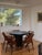 A sculptural round table crafted from richly aged, dark timber. The substantial tabletop showcases natural wood grain,...