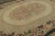 Handmade in wool, this 9x12 Antique Hooked rug, circa 1920-1929, features an elegant oval floral medallion framed by an...