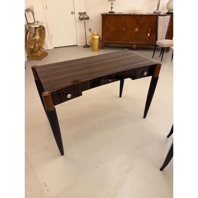 Frnech Art Deco writing desk with beautiful Macassar wood. The desk has a shaped top held by four tapered and channeled...