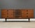 A mid century modern walnut dresser made by West Michigan Furniture with black inset pulls in the style of Arne Vodder....