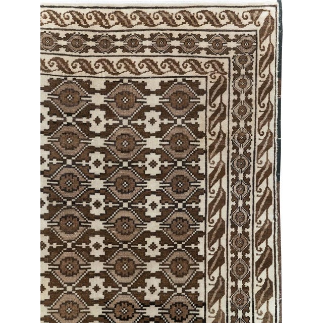 This Mid-20th century Turkish Anatolian accent carpet features a densely organized allover pattern rendered in a...