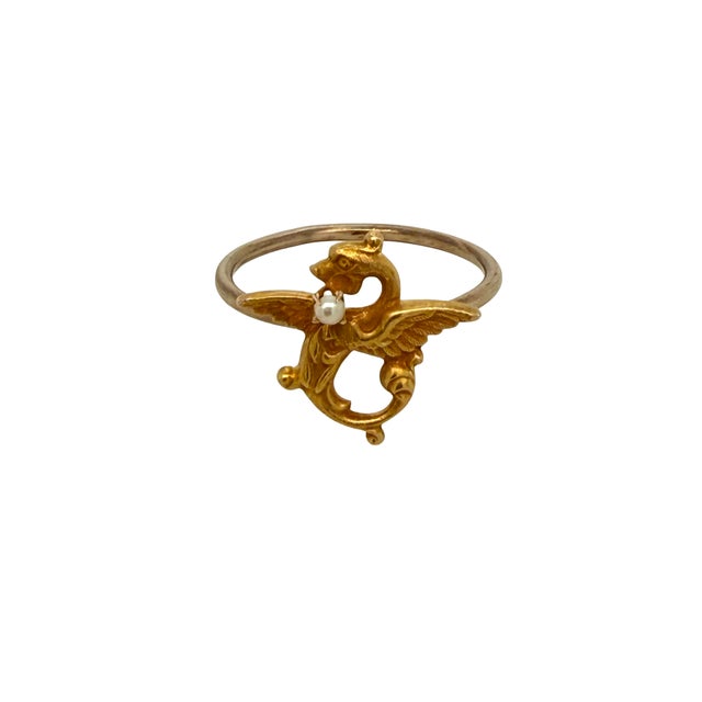 A beautifully detailed Victorian 14K gold ring featuring a griffin holding a seed pearl. Originally crafted as a stickpin...